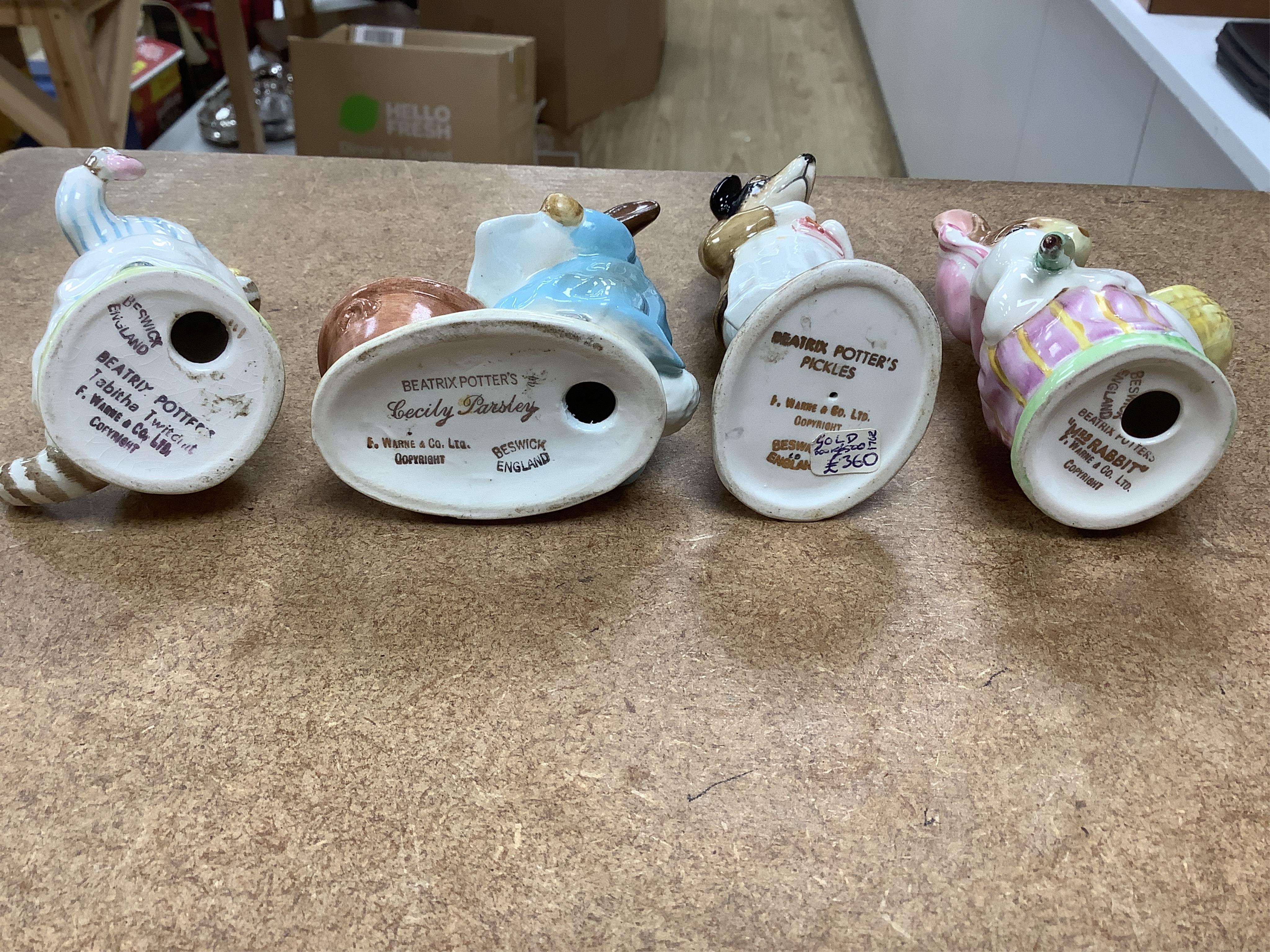 A collection of thirteen Beatrix Potter character figures, stamped with a gold stamp F Warne and Co Ltd, Beswick England, largest 12cm high